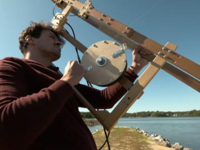 Image of a man with a kite flying mechanism.