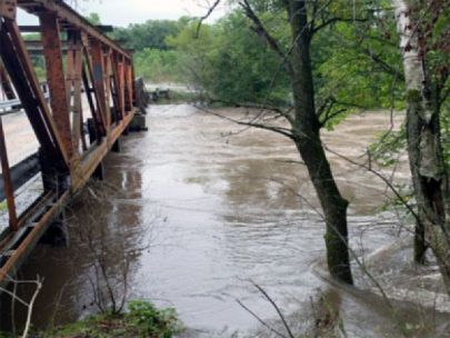 Flooding waterway passes under a bridge