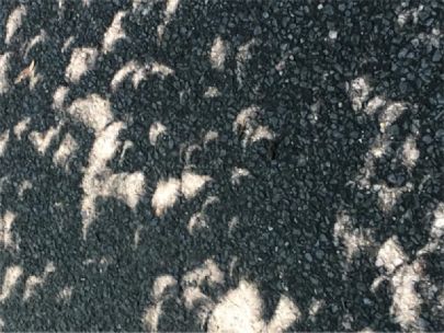 Crescent shaped sunlight shining on concrete