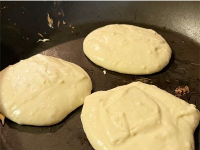Pancake batter cooking in a pan.
